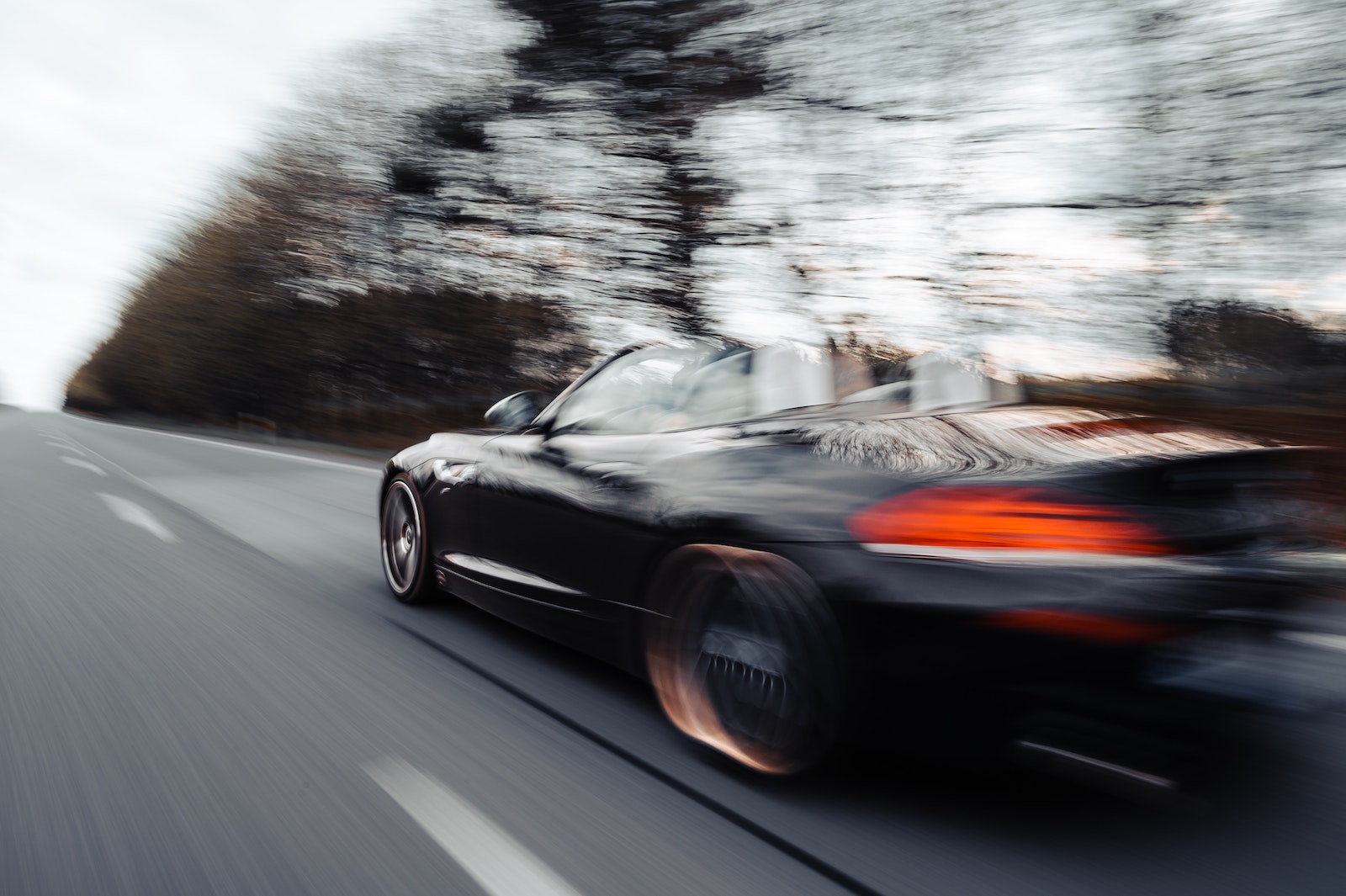 Black car driving at high speeds with blurred background