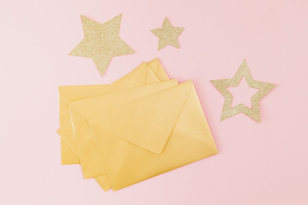 Gold stars surround a stack of gold envelopes